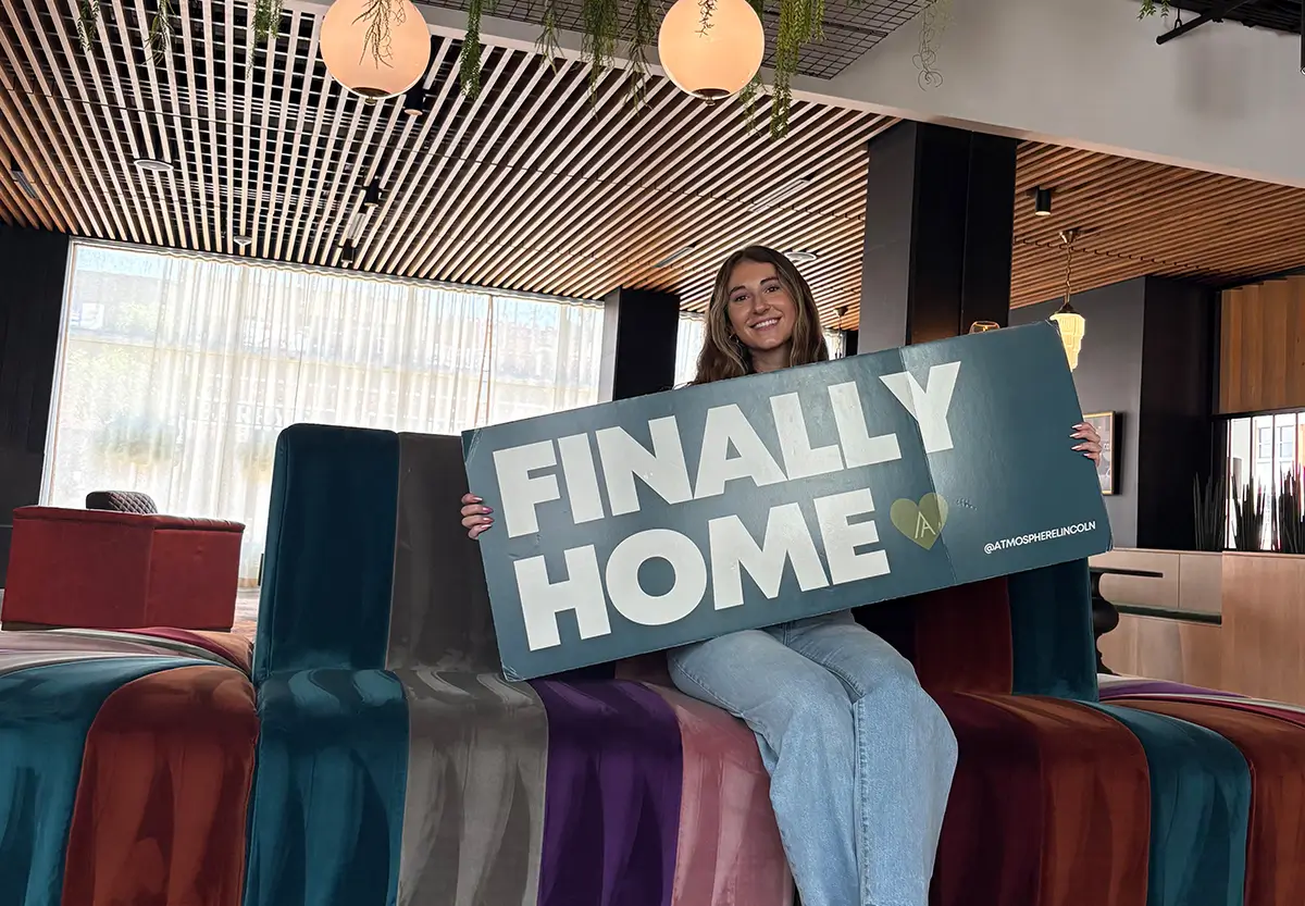 woman holding finally home sign
